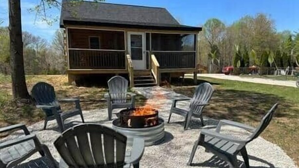 A cabin with a porch, outdoor seating, and a fire pit. - Deer View at Patoka Lake (Birdseye)