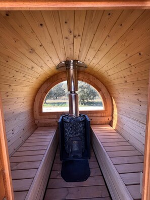 A wooden sauna with a stone interior and a chimney. - NUIKI Lodges (Montsegur-sur-Lauzon)