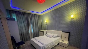 Una camera da letto moderna con un letto, comodini, una scrivania e una sedia.