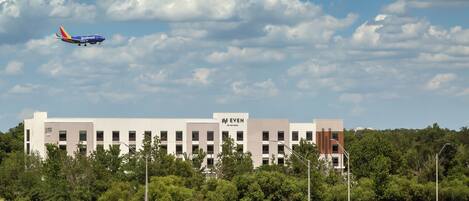 A modern building with a sign reading "EVEN" and a clear sky with clouds.