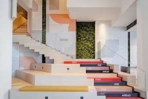 A modern staircase with steps labeled 'STAY,' 'ONE,' 'STEP,' and 'AHEAD.' - EVEN Hotel Shanghai Hongqiao CBD by IHG (Shanghai)