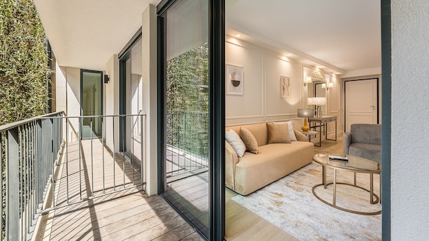 A modern apartment with a balcony, a living area with a sofa and coffee table, and a dining area with a lamp and table. - GuestReady - Chique home with balcony (Porto)