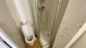 Ein kleines Badezimmer mit Toilette, Dusche und Waschbecken.