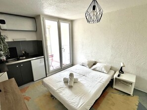 Une chambre à coucher avec un lit, une table de chevet et un luminaire suspendu.