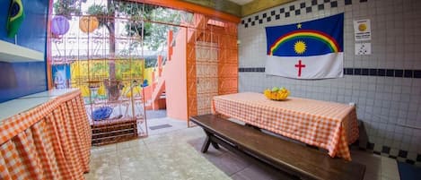 Une chapelle avec une table à carreaux, un drapeau et une croix accrochée au mur.
