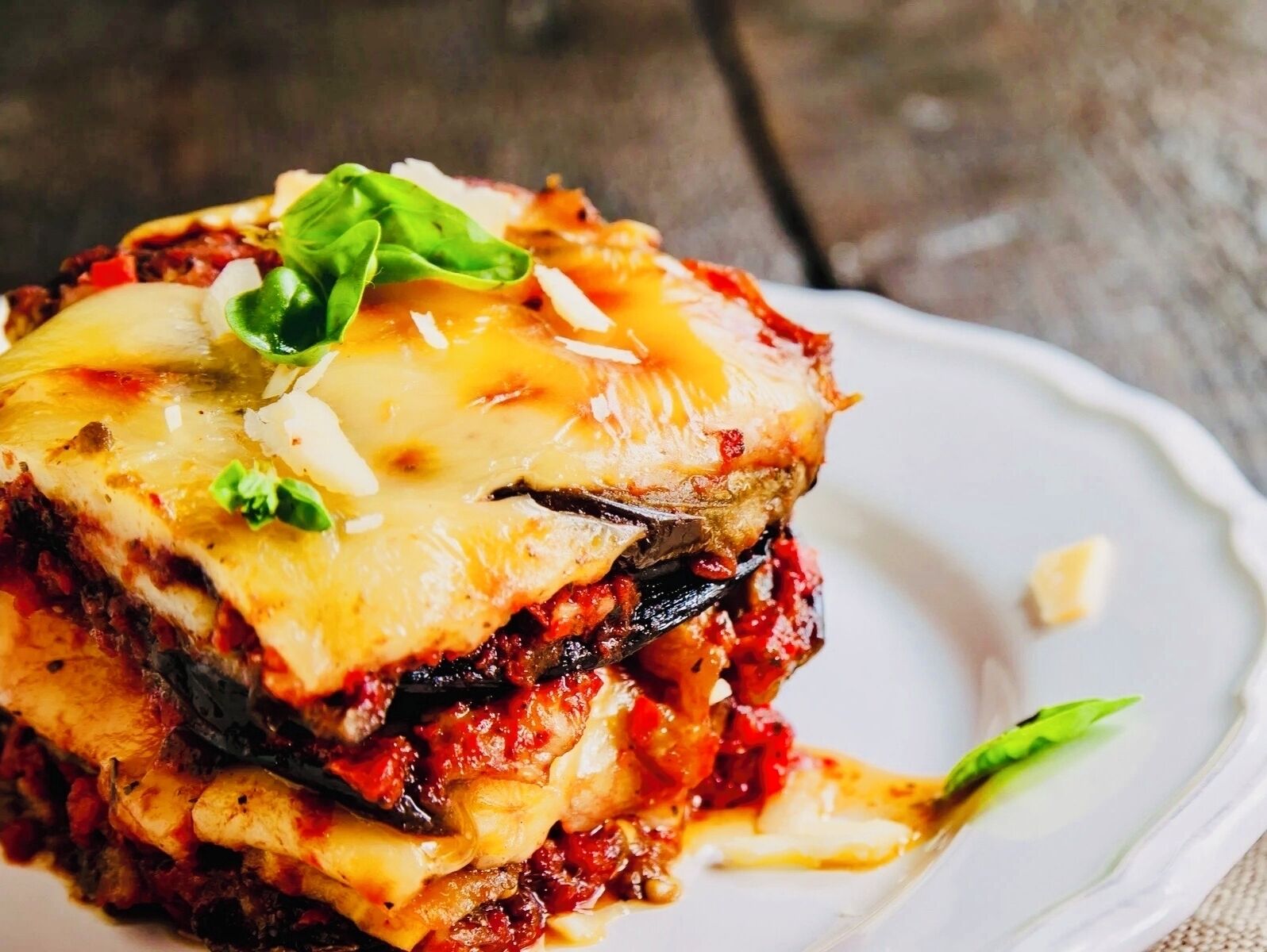 Un plat composé de plusieurs couches, avec du fromage fondu et une garniture sur le dessus.