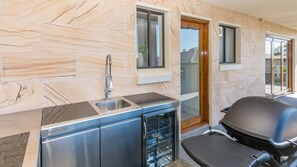 Een moderne keuken met een marmeren spatwand, roestvrijstalen apparatuur en een inbouwvaatwasser.