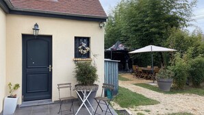 A house with a black door, a wreath on the window, and a patio with a table and chairs. - "Private and corporate rentals. 3 bedrooms and sofa bed. (Le Vaudoué)