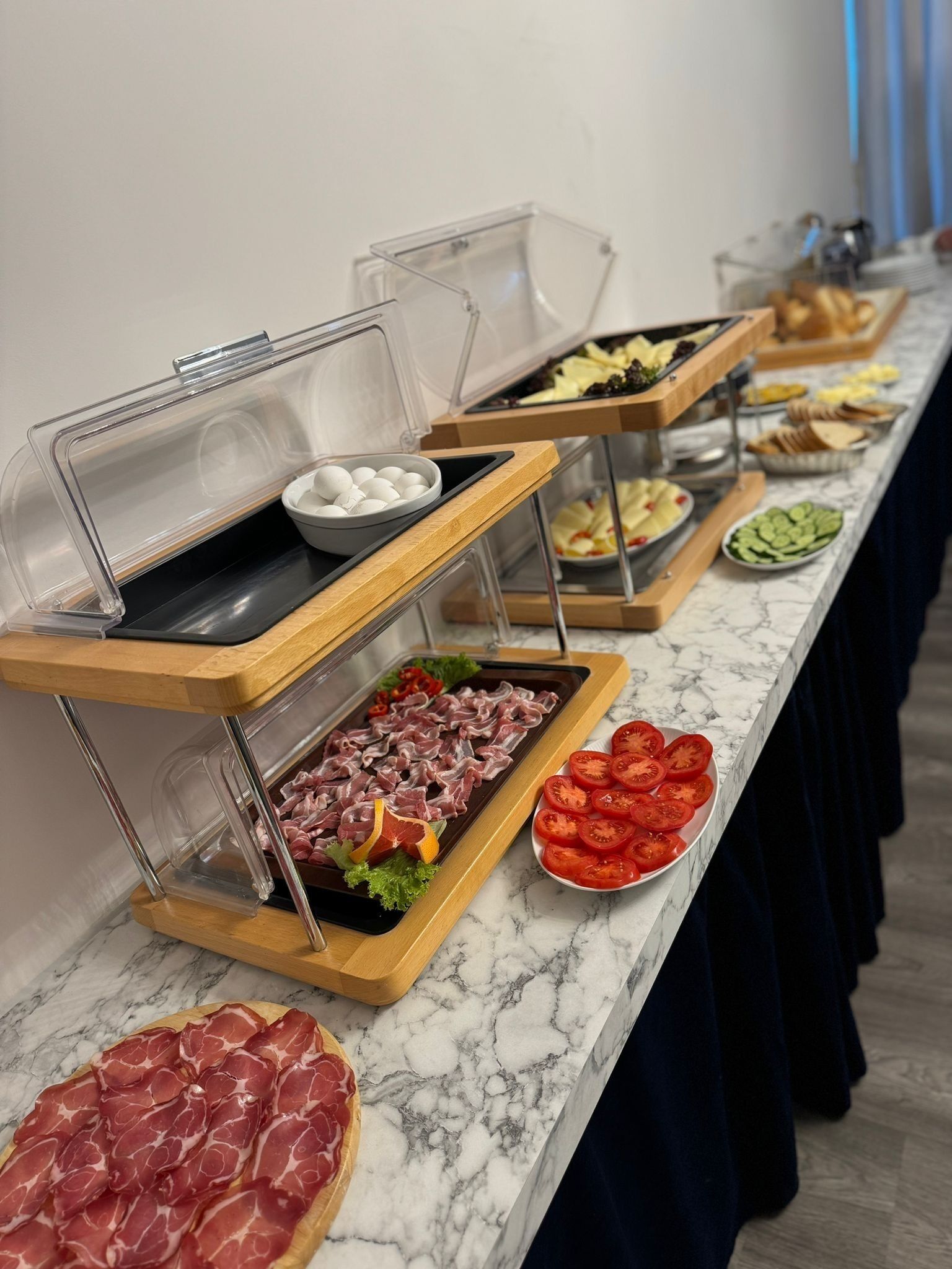 Un buffet proposant une variété de plats, notamment des viandes, des fromages et des fruits.