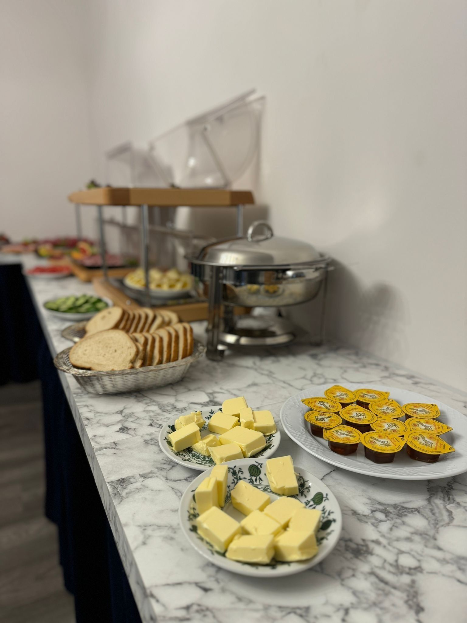 Ein reichhaltiges Buffet mit verschiedenen Speisen, darunter Butter, Brot und Joghurt.