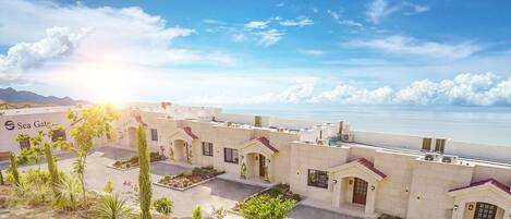 Un resort con varias construcciones, espacios al aire libre y vista al mar.