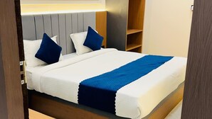 Una cama bien hecha con ropa de cama blanca y azul, un cabecero de madera y una mesita de noche.