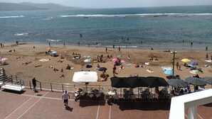 Ein Strand mit Sonnenschirmen und badenden Personen.