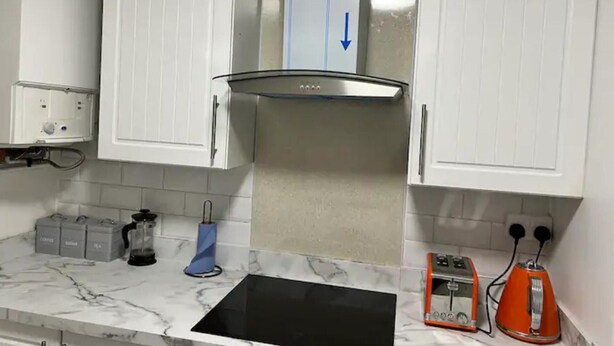 A kitchen with white cabinets, a black stove, a coffee maker, and a toaster. - 4 Guests - 10min Airport - N E C - Jaguar (Solihull)