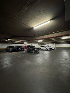 Un aparcamiento subterráneo de varios niveles con varios coches estacionados.