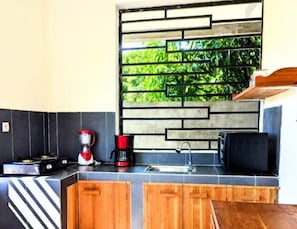 Departamento Confort, vista al jardín | Cocina privada | Refrigerador, microondas, horno y parrilla de estufa