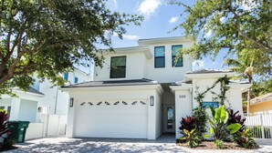 A two-story house with a white garage door, a small porch, and a number "588" on the side. - Sorrento Cabana: 1-Bedroom Cabana Near Vanderbilt Beach – Perfect for a Tranquil Beachside Escape (Naples)