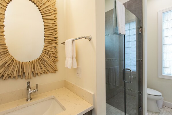 A bathroom with a marble sink, a glass shower enclosure, and a toilet. - Sorrento Cabana: 1-Bedroom Cabana Near Vanderbilt Beach – Perfect for a Tranquil Beachside Escape (Naples)
