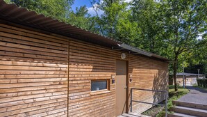 Eine Holzhütte mit einem Metall-Dach, einem kleinen Fenster und einer Tür.
