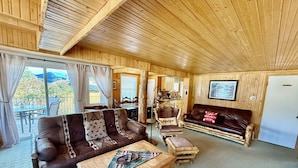 Un interior acogedor de cabaña de madera con sofá, sillón y mesa de centro.