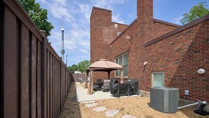 Een bakstenen gebouw met een patio, compleet met buitenmeubilair en een airconditioner.