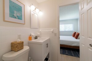 Une salle de bain avec des toilettes, un lavabo et un tableau encadré au mur.