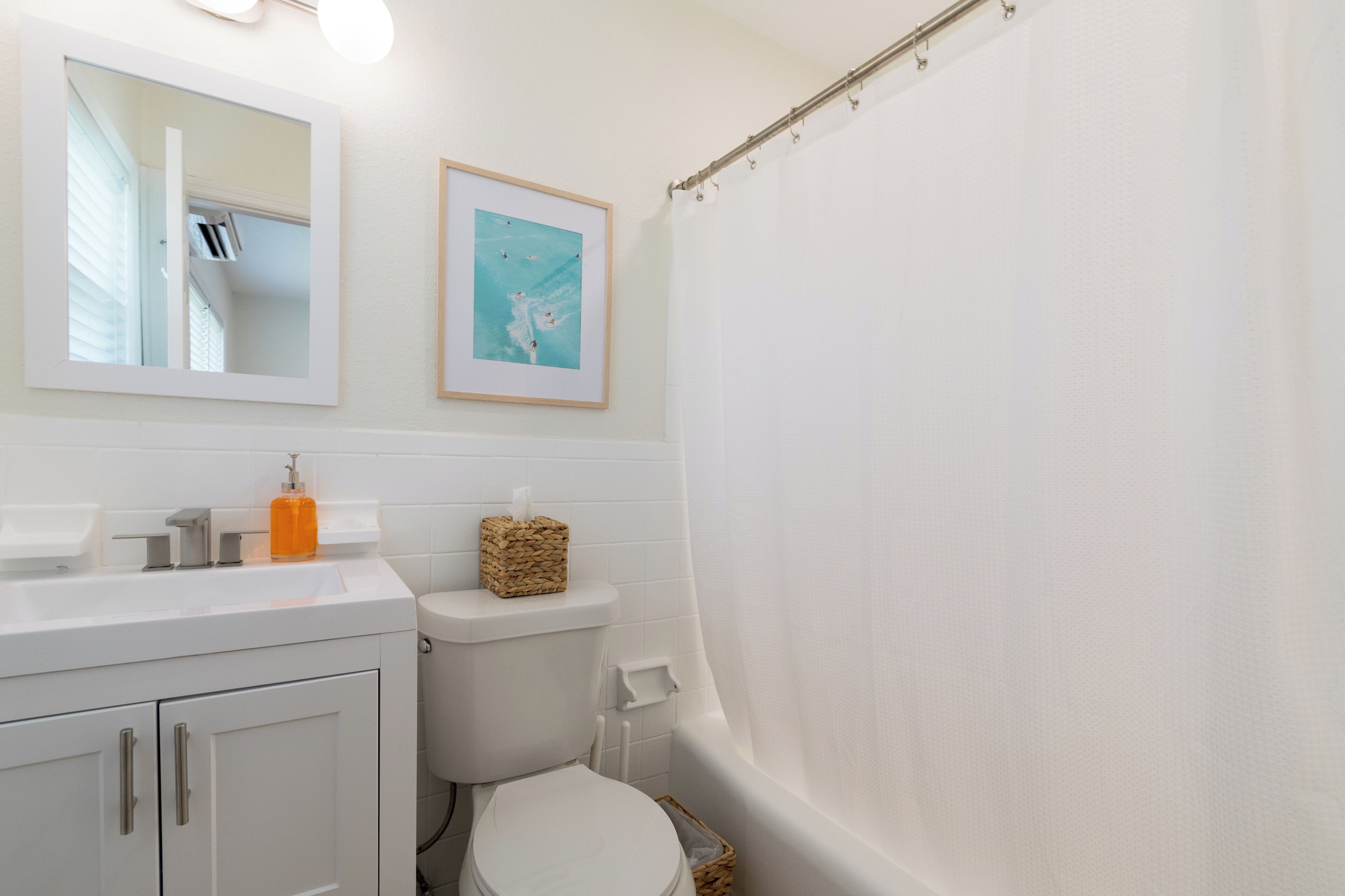 Une salle de bain équipée de toilettes, d’un lavabo et d’un rideau de douche.