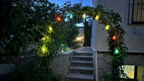 A stone staircase leading to a door, surrounded by greenery and decorative lights. - VILLA LOS ALMENDROS WITH PRIVATE POOL  (Calpe , Alicante)
