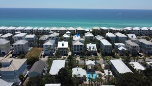 A coastal resort with multiple-story buildings, a central swimming pool, and a view of the ocean. - Beautiful 4-br 3 king beds, 20 seconds to beach, community pool (Destin)