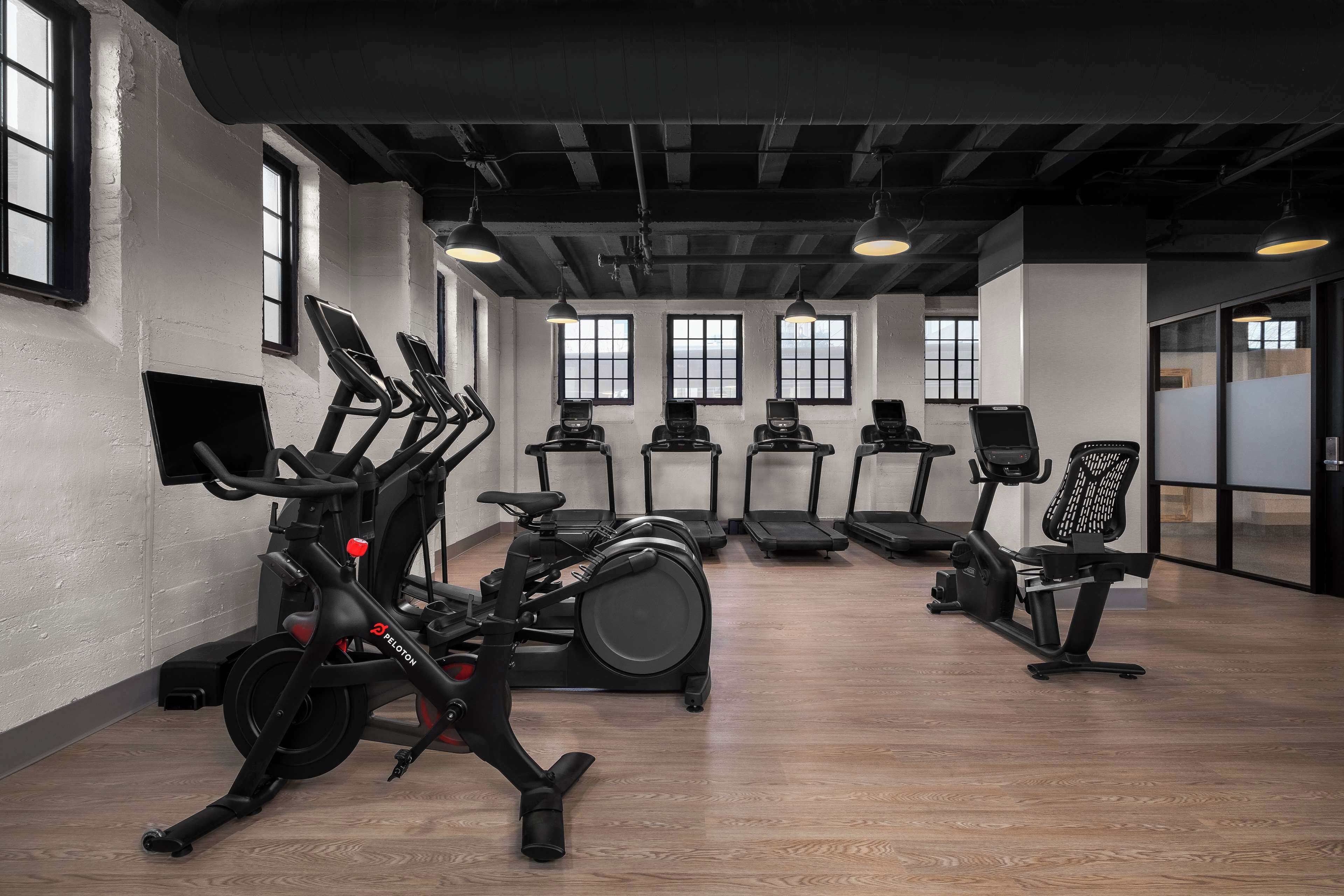 Et fitnesscenter med motionscykler, løbebånd og træningsstole.