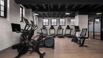 Et fitnesscenter med motionscykler, løbebånd og træningsstole.