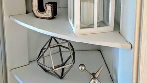 Une étagère ornée d’une étoile décorative, d’une enseigne portant l’inscription « MASSACHUSETTS » et d’une lettre « G ».