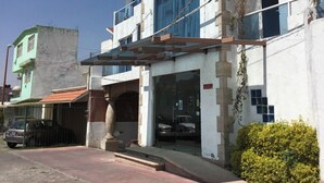 A multi-story building with a prominent arched window and a covered entrance. - Hotel Cancalli Tlaxcala (Tlaxcala)