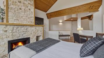 Quarto com lareira, cama, escrivaninha e cadeira.