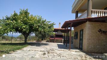 A stone-paved pathway leading to a building with a tiled roof and a balcony.