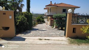 Una entrada cerrada con un camino de piedra que conduce a un edificio con tejado de tejas.