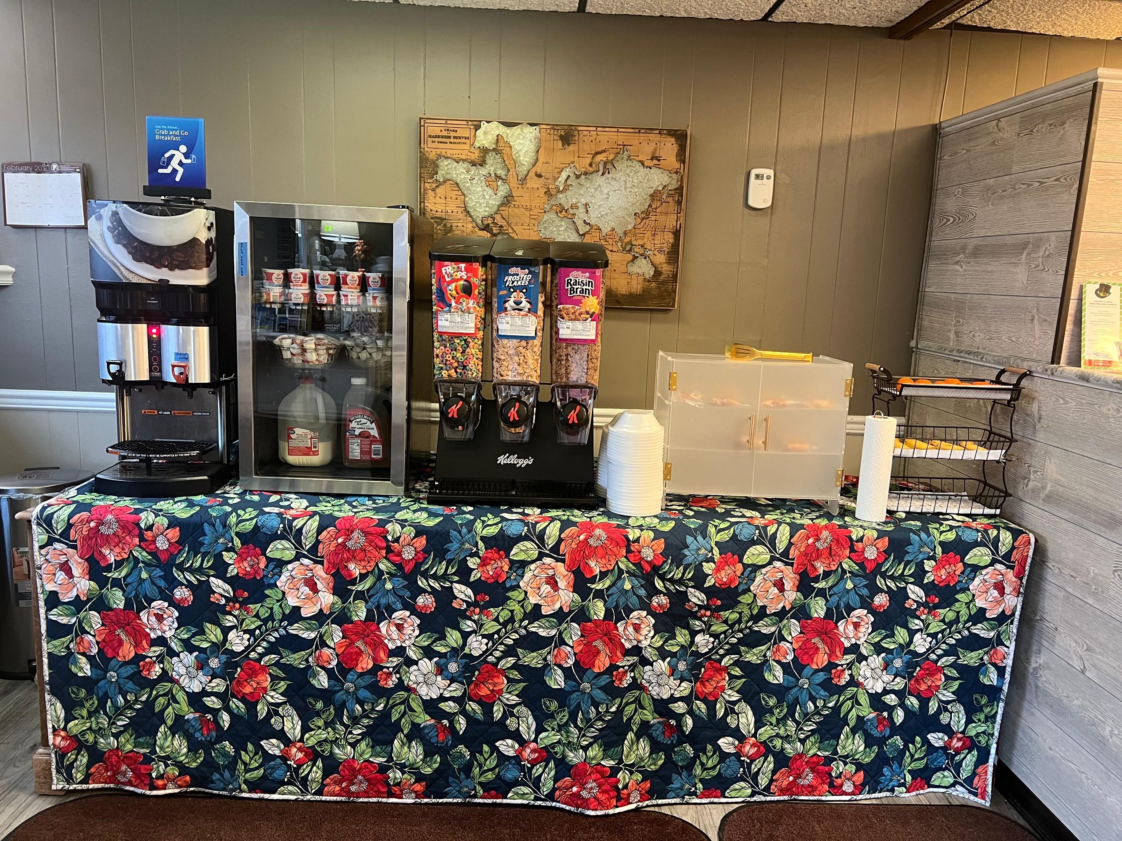 A breakfast station with a coffee machine, cereal dispensers, and a milk cooler.