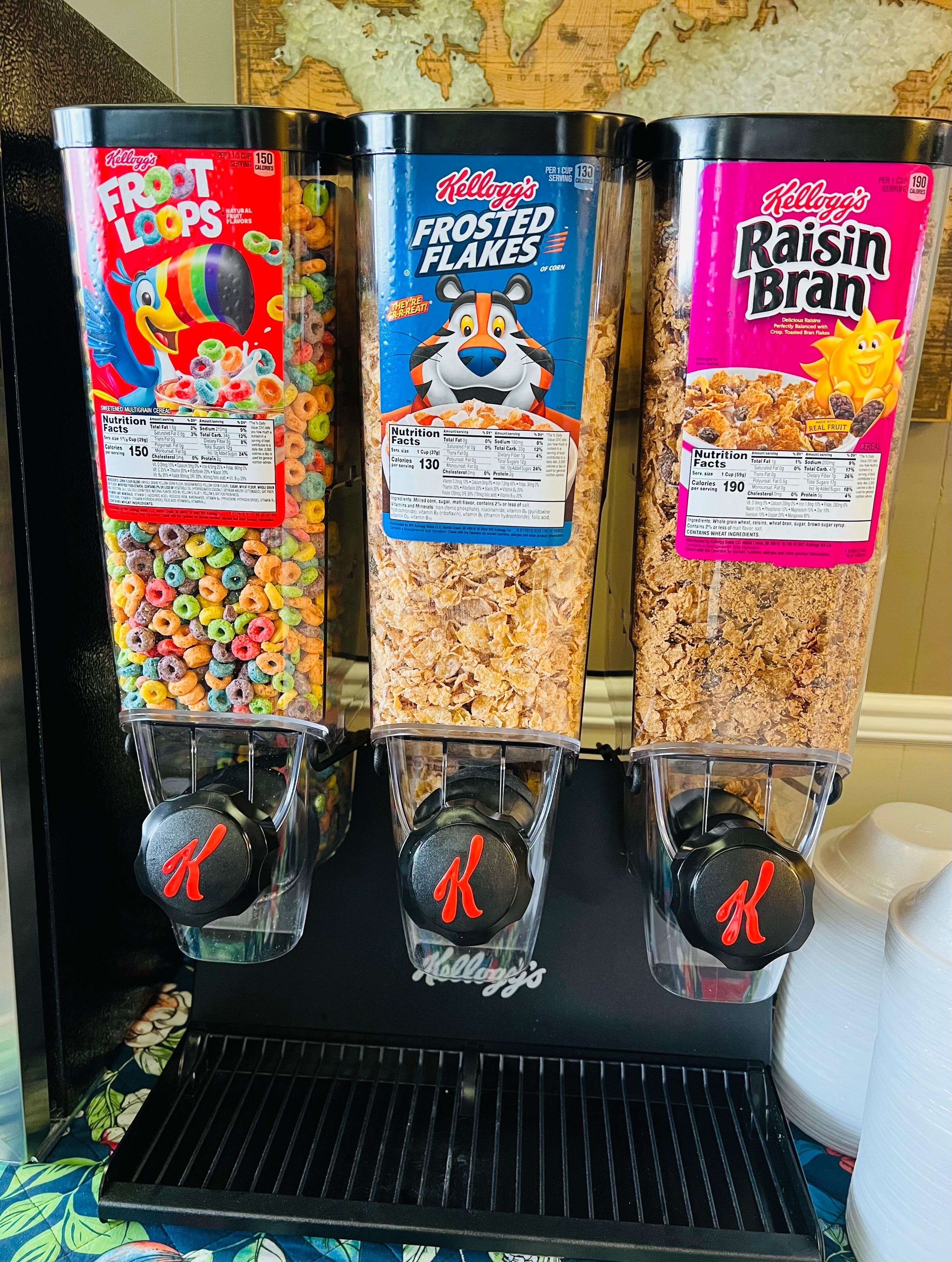 A cereal dispenser with three different brands: Kellogg's Frosted Flakes, Kellogg's Raisin Bran, and Kellogg's Froot Loops.