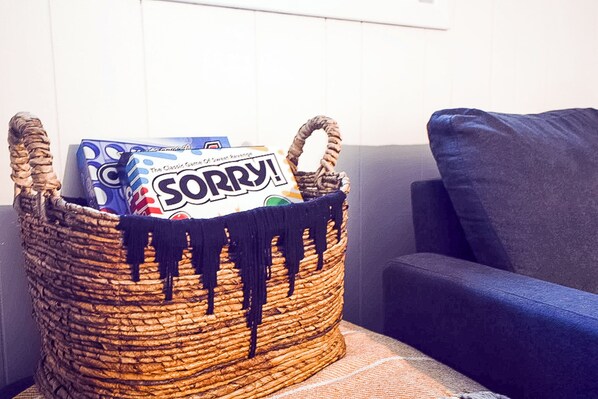 A woven basket with a 'SORRY!' sign and a box of tissues on a textured fabric surface next to a blue couch. - Charming 4-bedroom house with Private Pool near Savannah (Pooler)