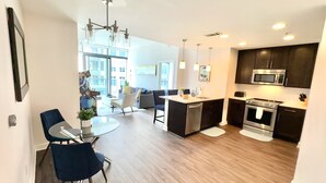 A modern kitchen with dark cabinets, stainless steel appliances, and a central island.