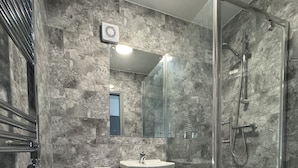 A bathroom with a toilet, sink, and glass shower enclosure. - Waverley park house (Preston)