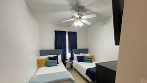 A hotel room with two beds, a ceiling fan, a window with curtains, and a television. - Lawton/Fort Sill Home near Airport  (Lawton)