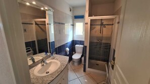 A bathroom with a sink, toilet, and shower.