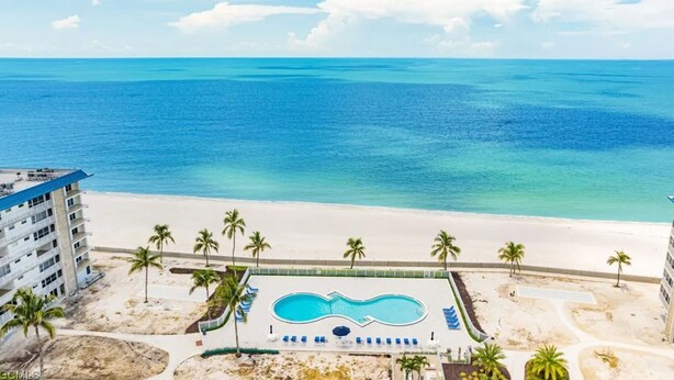 A resort with a pool, beach, and ocean view.