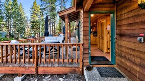 A wooden cabin with a deck, outdoor seating, and a door leading inside. - Cedar Flat - Views of the Lake! (Carnelian Bay)