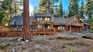 A cabin with a wooden exterior, a deck, and a garage. - Cedar Flat - Views of the Lake! (Carnelian Bay)