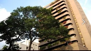 A modern building with multiple balconies, some with plants. - Hotel Cuarta Avenida (Caracas)