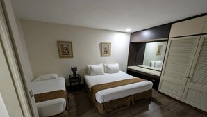 A hotel room with two beds, a desk, a mirror, and a wardrobe. - Hotel Cuarta Avenida (Caracas)