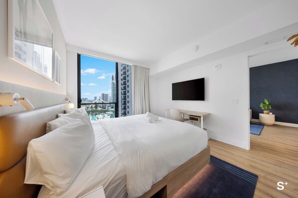 A modern hotel room with a large bed, a flat-screen TV, a city view, and a small desk. - Stayplus Luxury Condo in Downtown Miami (Miami)