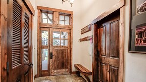 A wooden door with a glass panel, a bench, and a sign reading "Rocky Mountain High Colorado". - Ski-in 2 Bedroom Townhome at Mountain Thunder (Breckenridge)